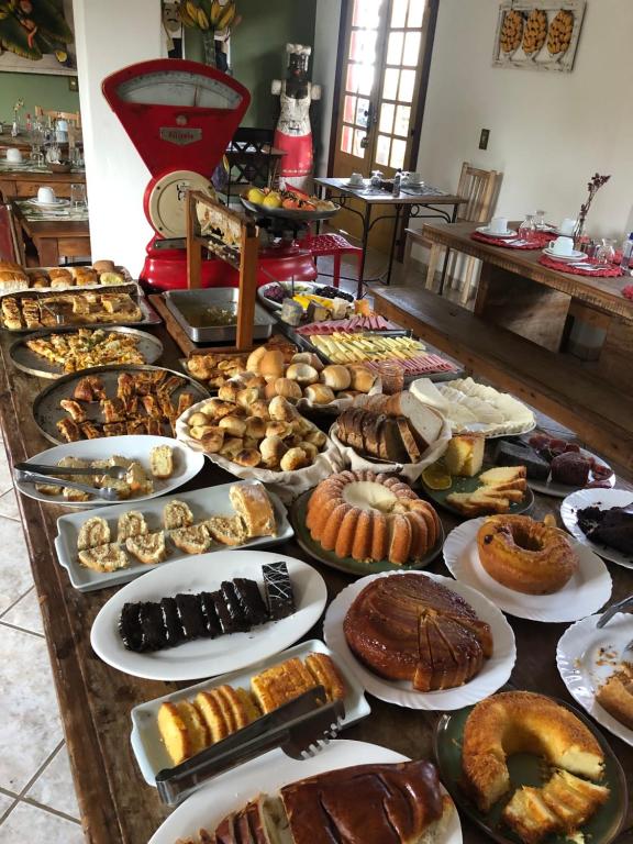 a table filled with lots of different types of pastries at Pousada Vó Iris in Tiradentes
