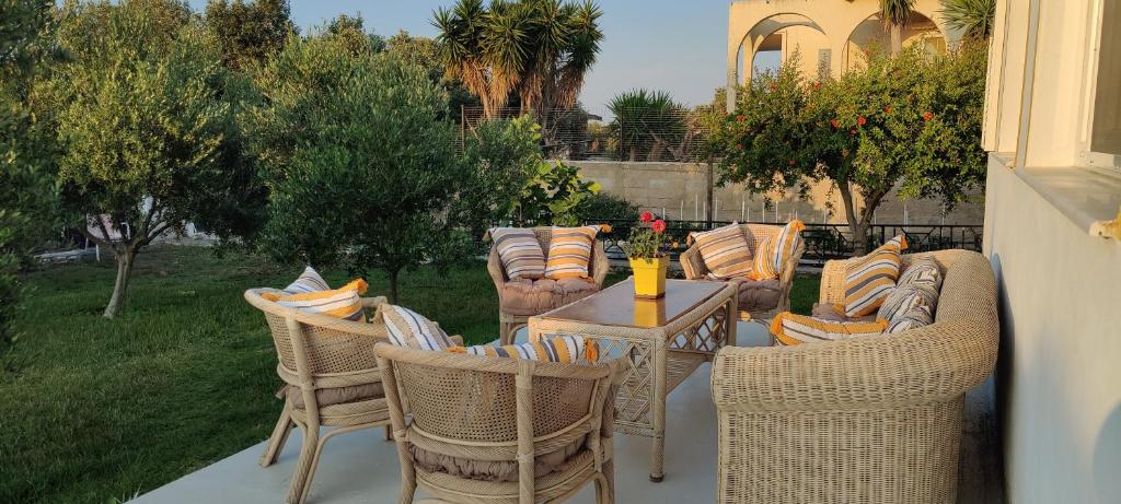 a patio with wicker chairs and a table with a tableasteryasteryasteryastery at Villa Katerina in Kos
