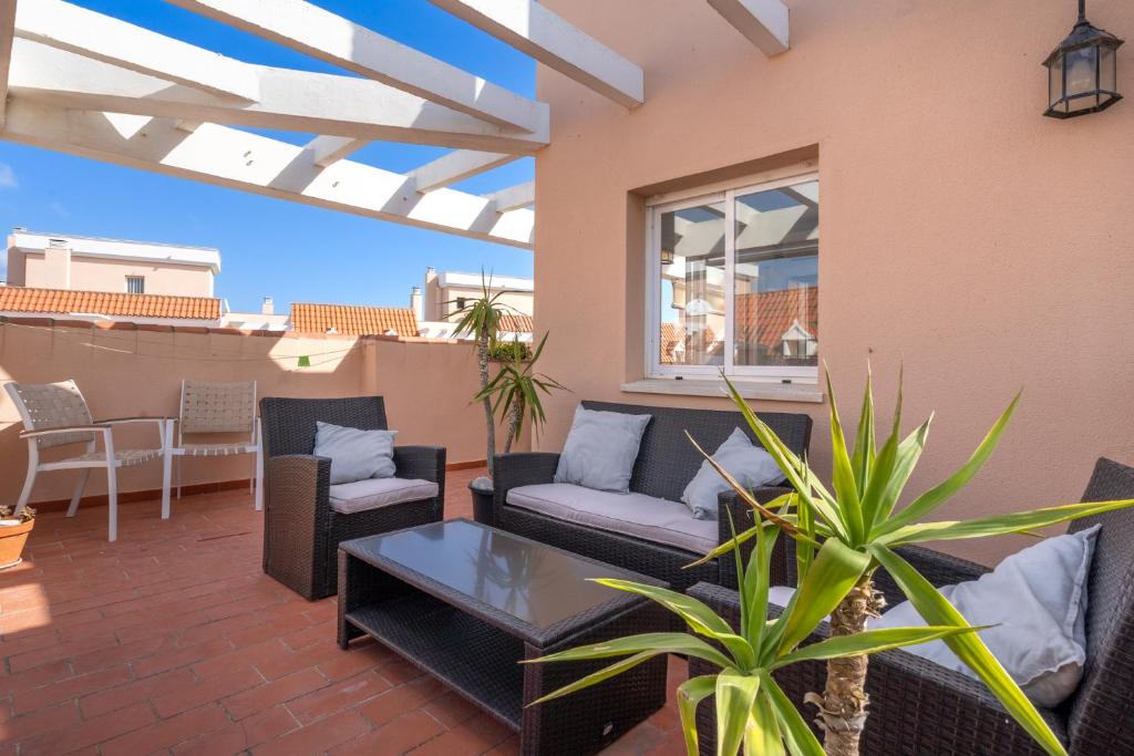 a patio with couches and a table on a building at 28 Rooftop apartment close to the beach Sabinillas in San Luis de Sabinillas