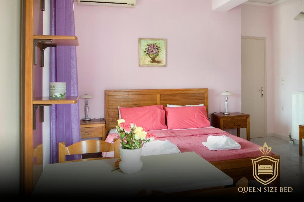 een slaapkamer met een bed en een tafel met bloemen erop bij Sunny Apartments - ex Zoi Studios in Daratso