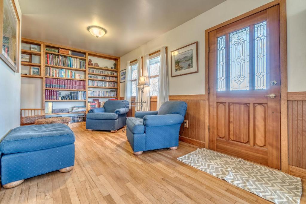 una sala de estar con 2 sillas azules y una puerta en Shady Acres - Country Classic, Spectacular Views!, en Fruita