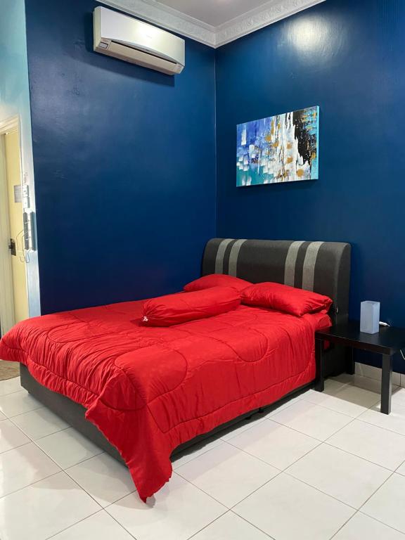 een blauwe slaapkamer met een bed met een rode deken bij DF ZaheenulFitri Homestay (Muslim Homestay) in Seremban