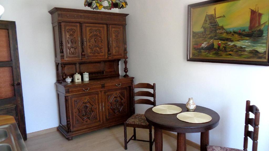 a dining room with a table and a wooden cabinet at Mieszkanie z kuchnią i łazienką in Augustów