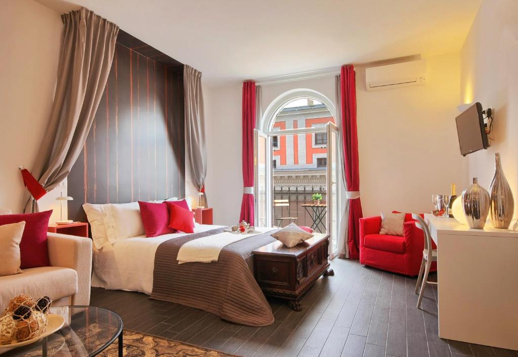 ローマにあるルレ クアトロ フォンターネのベッドルーム1室(ベッド1台、ソファ、窓付)