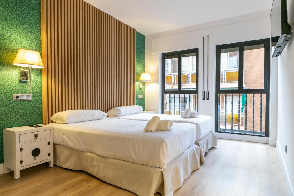 1 dormitorio con 2 camas y paredes verdes en H-A Aparthotel Hotel Quo, en Madrid