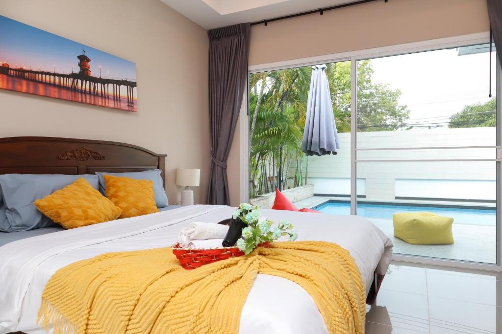 パタヤ・サウスにあるCityHouse-OSCAR,pool villa 4Bedrooms-Jacuzzi-walking Street 10minのベッドルーム1室(黄色い毛布付きのベッド1台付)