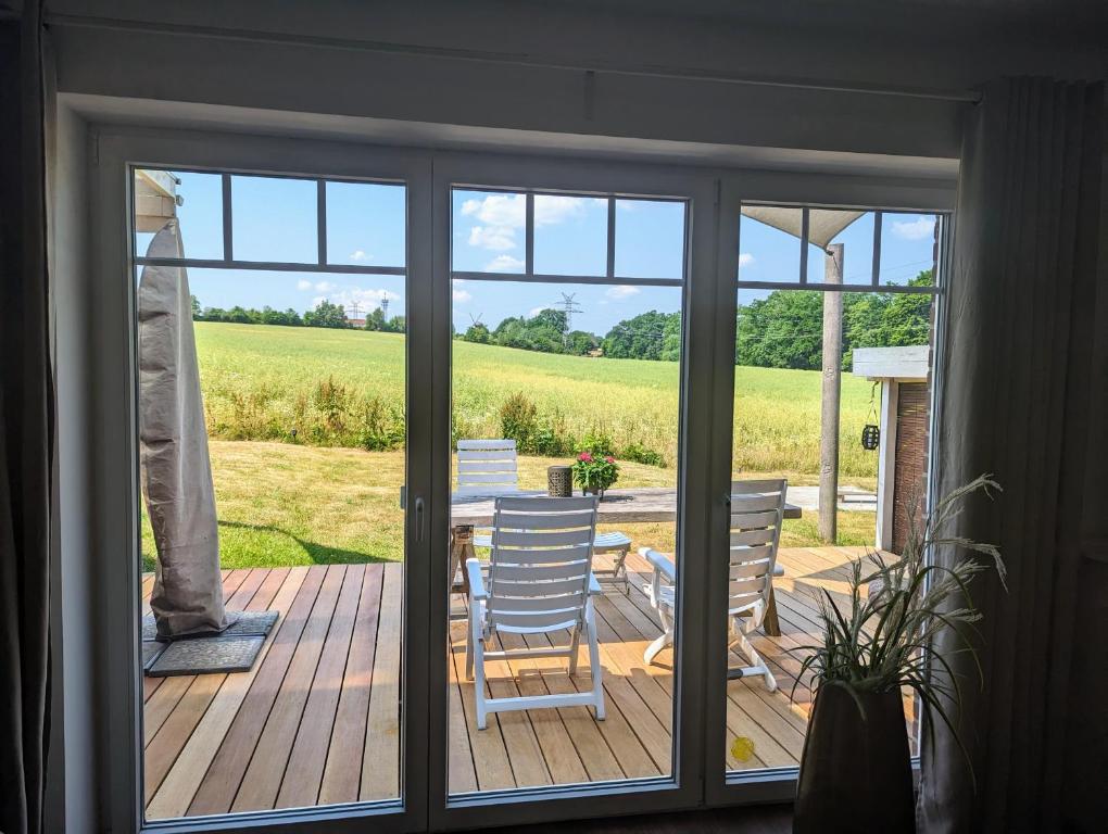 eine Glasschiebetür mit einem Tisch und Stühlen auf einer Terrasse in der Unterkunft Ferienwohnung Seestern in Reinbek in Reinbek