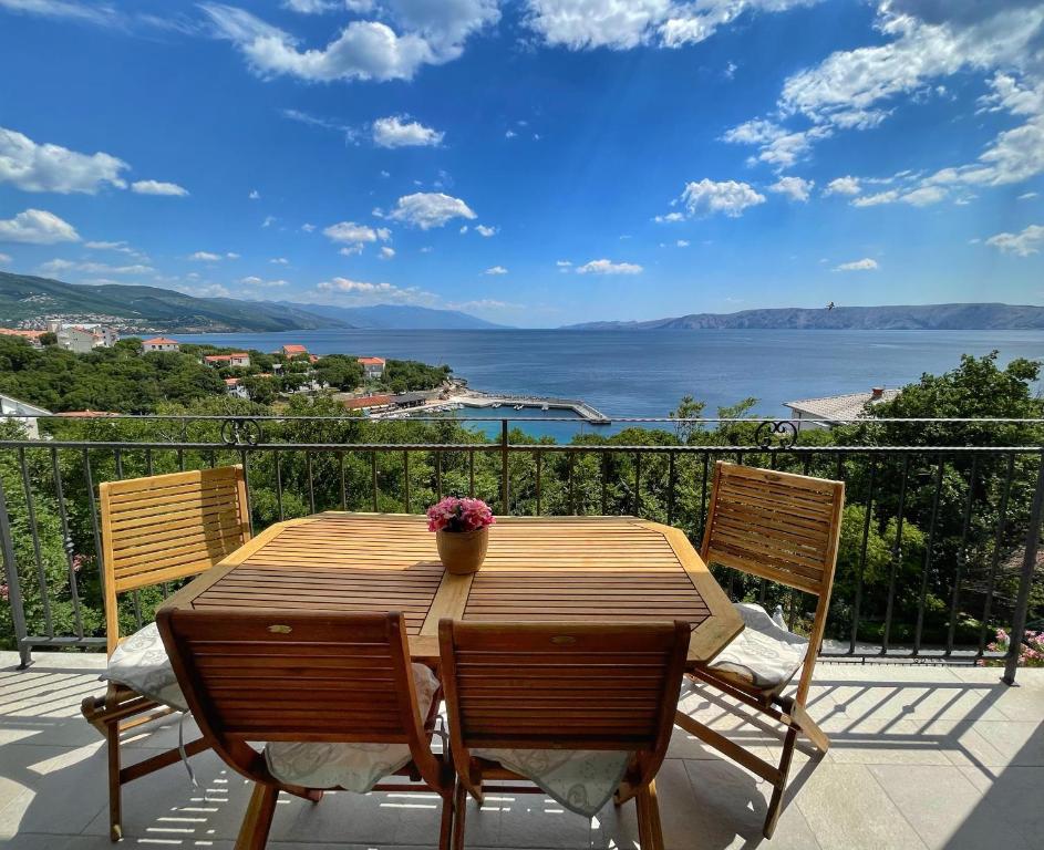 a wooden table and chairs on a balcony with a view of the water at Apartments Gajeta in Povile