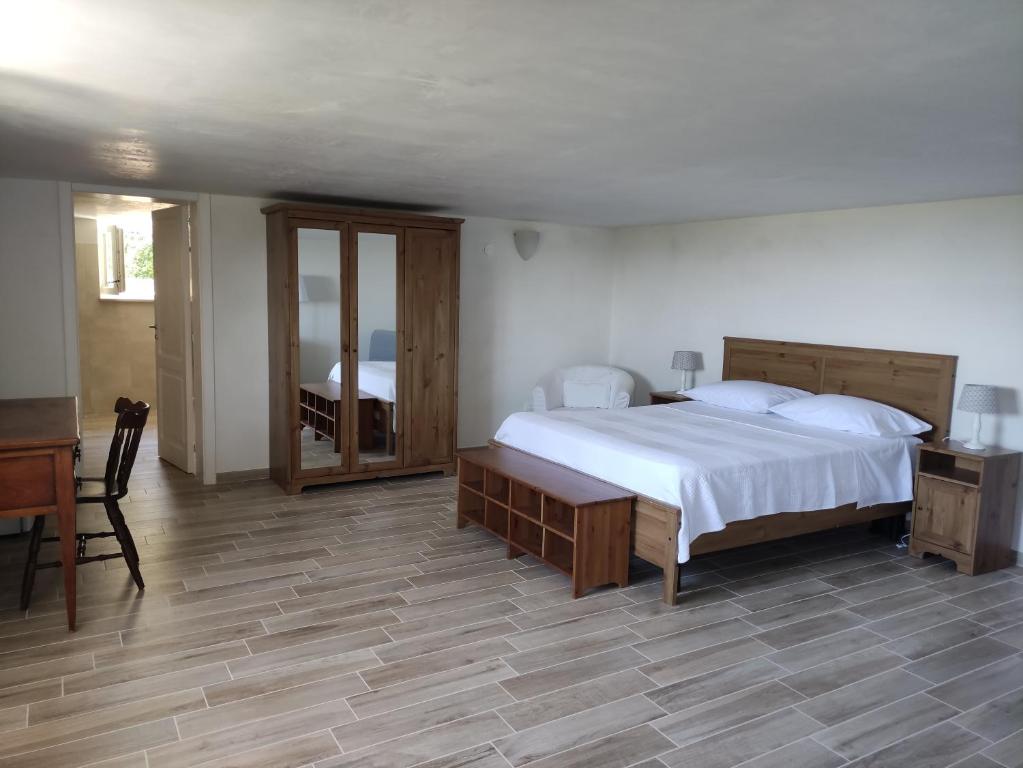 1 dormitorio con cama, mesa y espejo en DIMORA DEL CUORE - IL MELOGRANO, en Monopoli