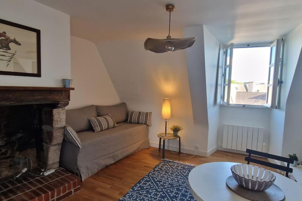 ein Wohnzimmer mit einem Sofa und einem Kamin in der Unterkunft Au cœur des remparts in Vannes