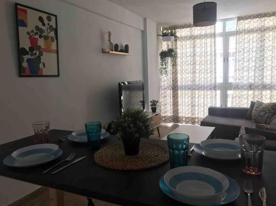uma sala de estar com uma mesa com pratos em Ideal apartamento en el Barrio de las Delicias em Málaga
