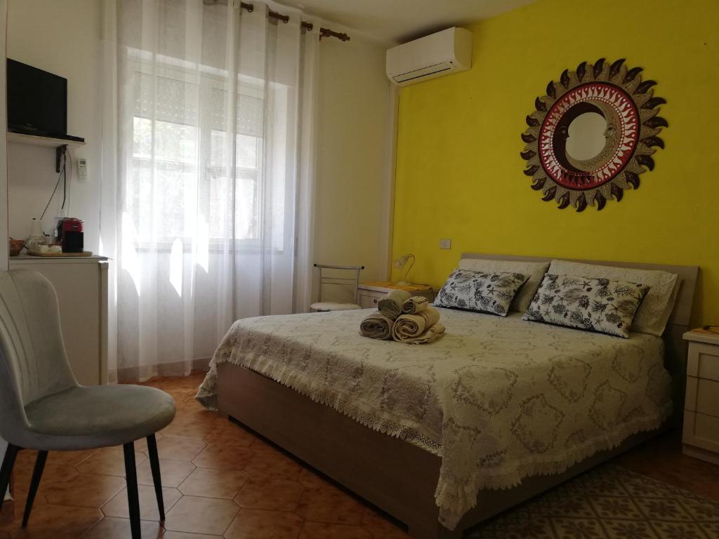 1 dormitorio con 1 cama con espejo y silla en A Domo Mia, en Castelsardo