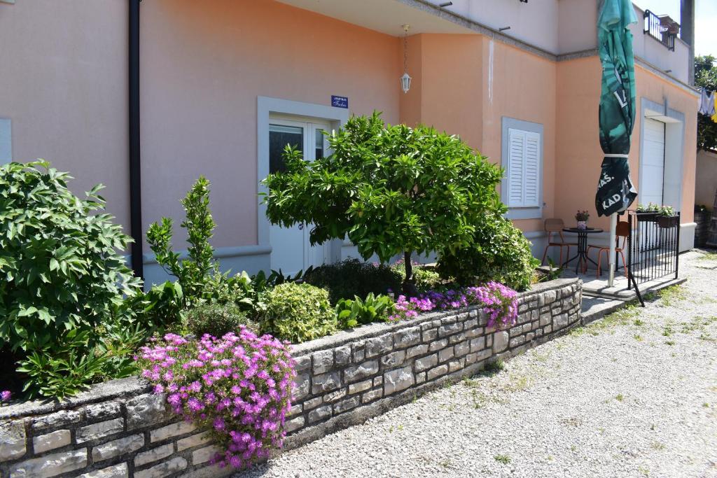 a garden in front of a house with flowers at Apartman Fachin in Motovun