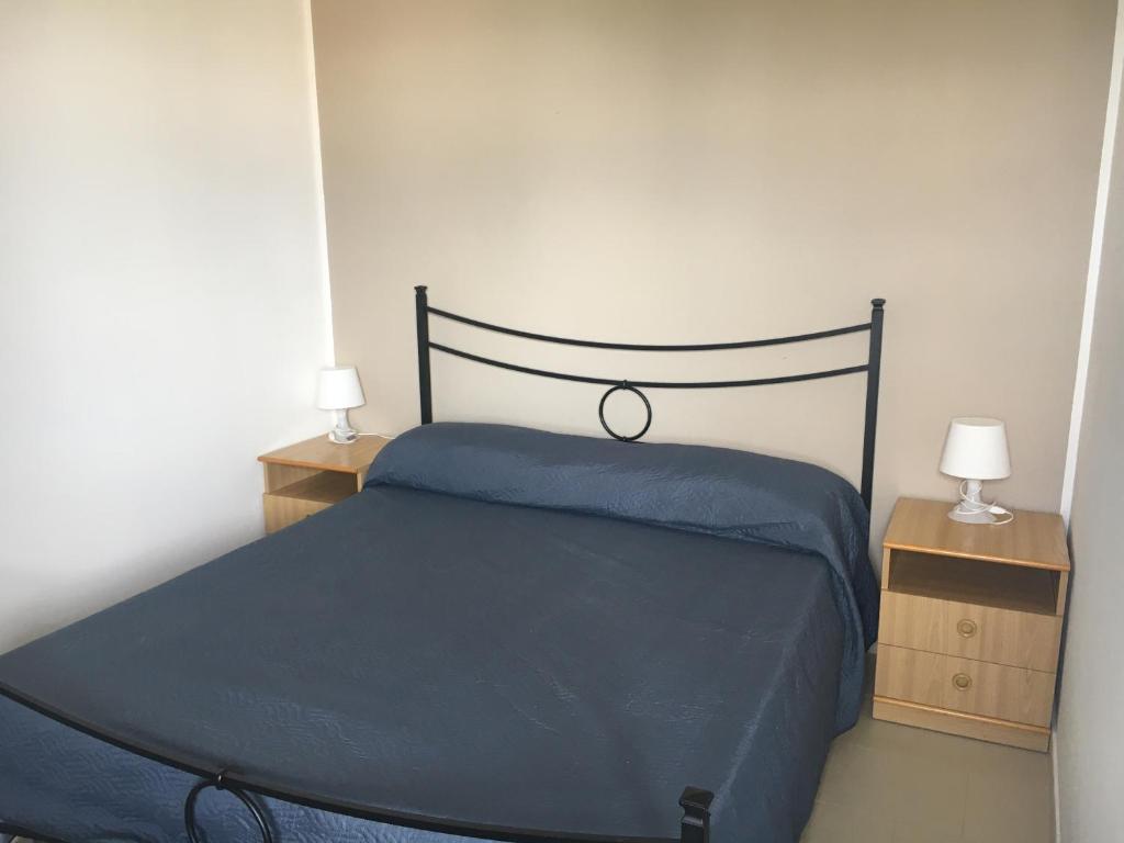 - une chambre avec un lit bleu et 2 tables de nuit dans l'établissement Home Minerva, à Giardini Naxos