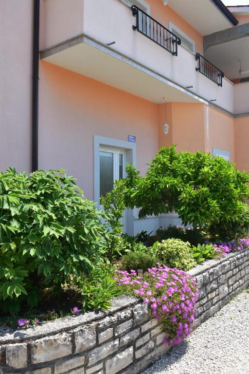 a garden in front of a building with flowers at Apartman Fachin in Motovun