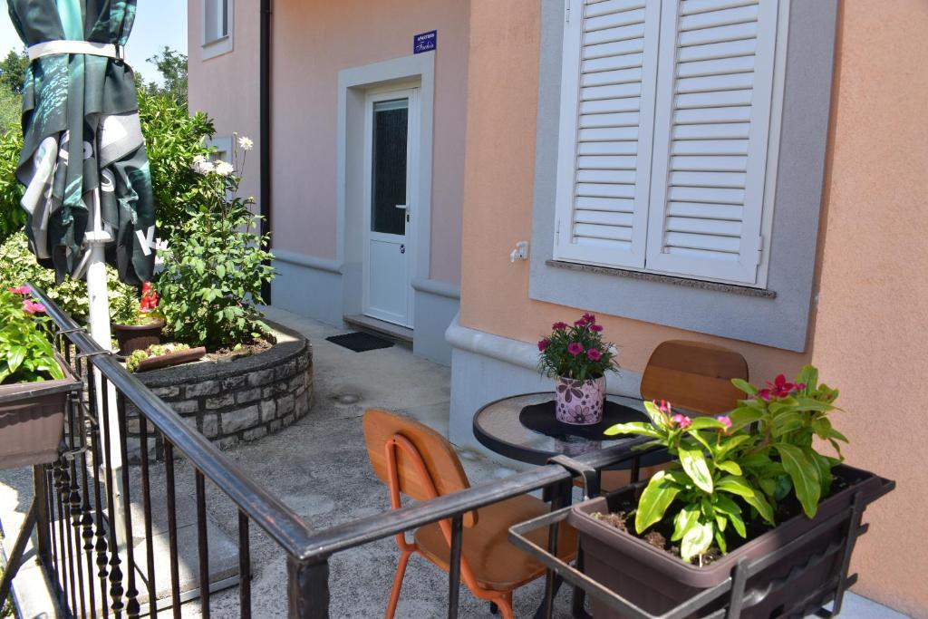 a balcony with a table and chairs and plants at Apartman Fachin in Motovun