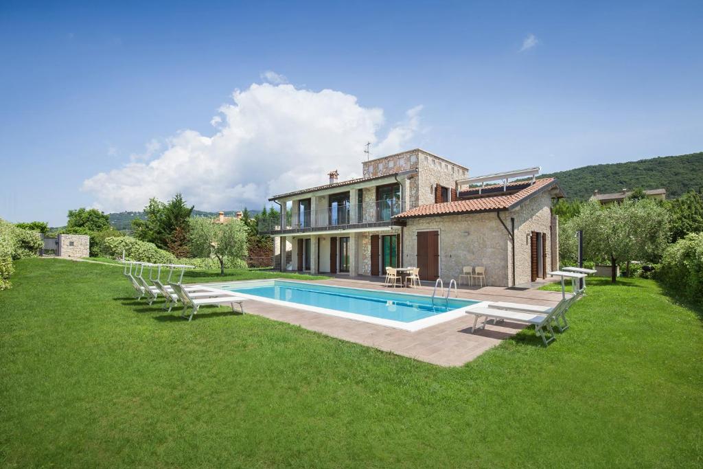 a house with a swimming pool in the yard at Cà Bosca in Torri del Benaco
