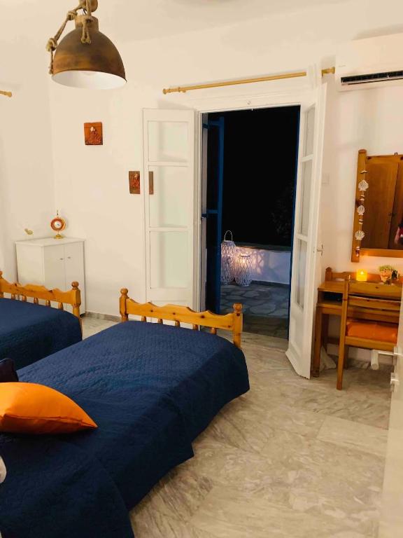 a bedroom with two beds and a sliding glass door at Limni No 2 self catering apartment in Posidhonía