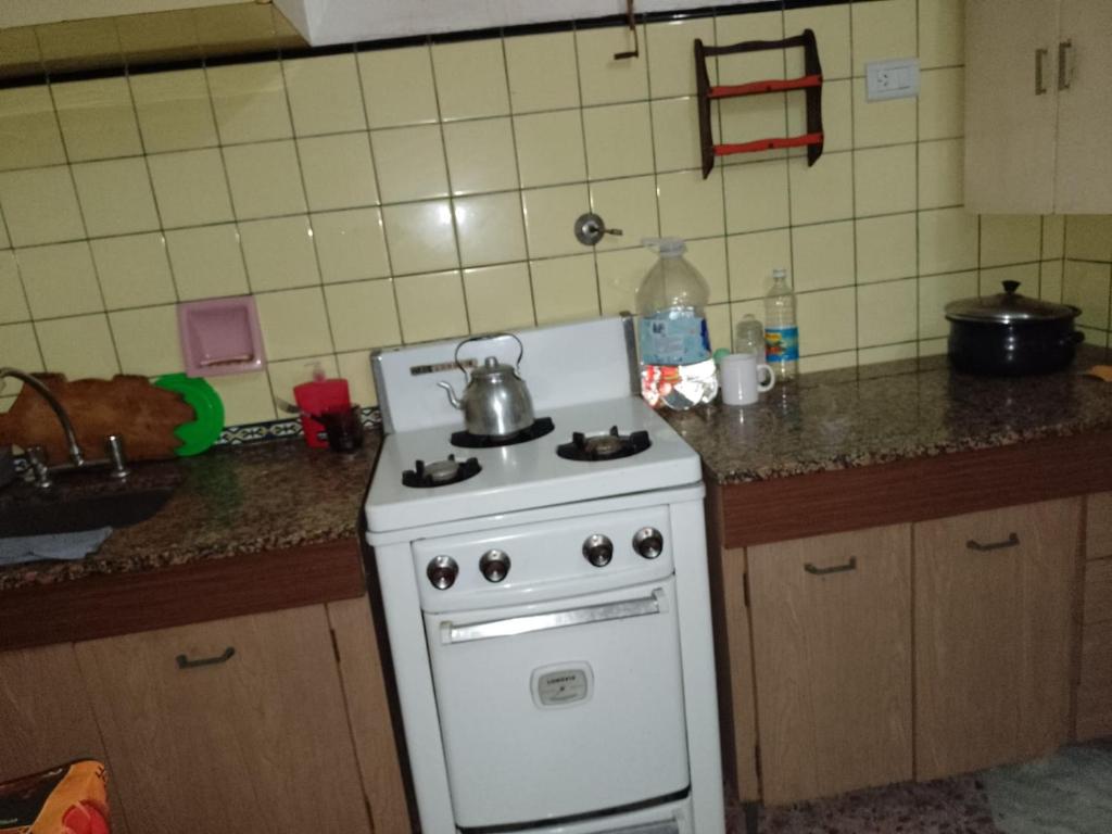 a kitchen with a white stove with a tea kettle on it at LA MAGA in Remedios de Escalada
