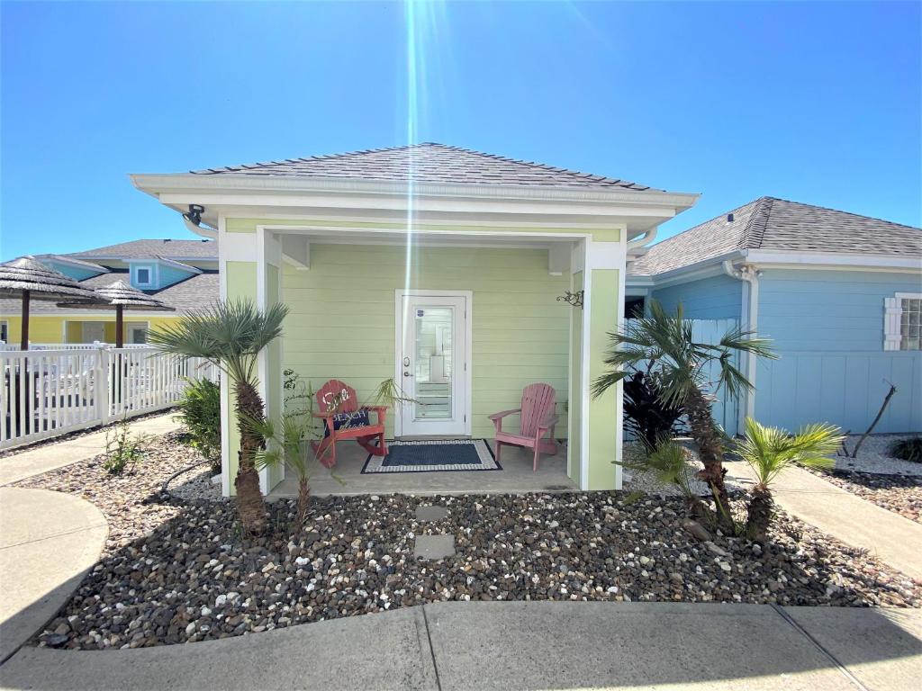 a house with two pink chairs in the front yard at Island Time in Port Aransas