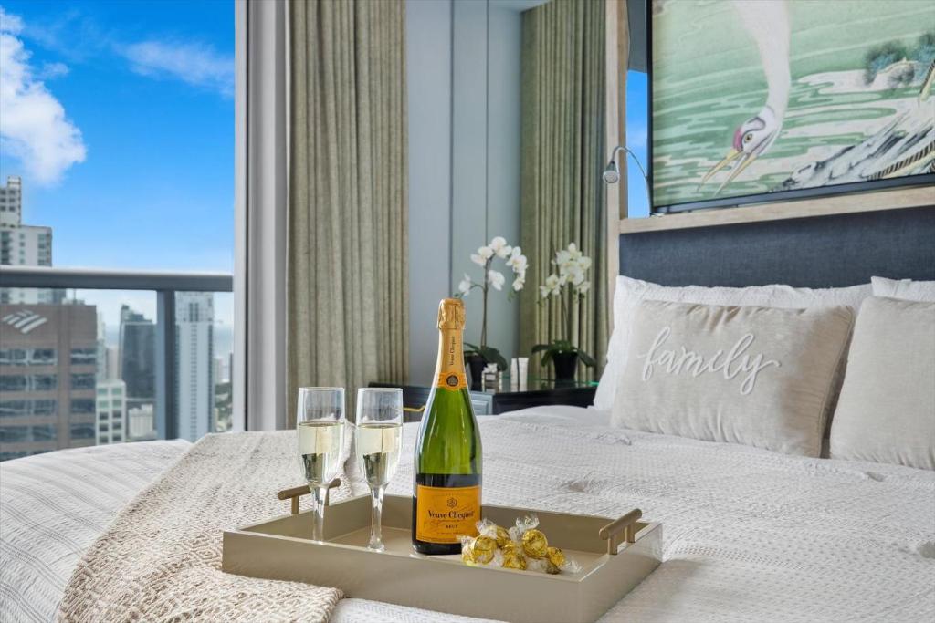 a bottle of champagne and two glasses on a bed at Special Offer at Icon Brickell with Ocean view in Miami