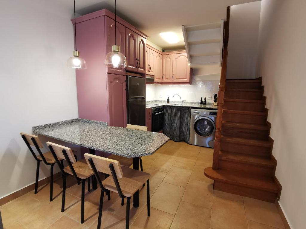 una cocina con mesa y sillas y una escalera en Casa Guadalupe en Llanes