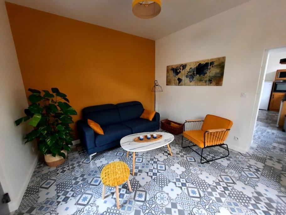 a living room with a blue couch and a table at La Parenthèse Fléchoise, Gîte in La Flèche