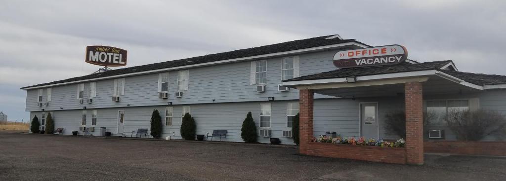 a motel with a sign on the side of a building at Amber Inn Motel in Bliss