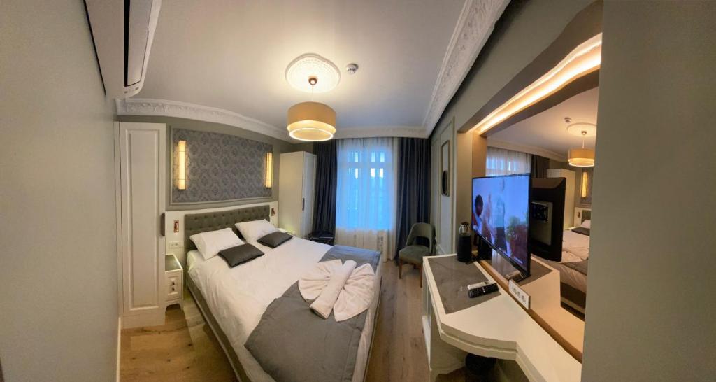 فندق تريادا تقسيم - الفئة الخاصة في إسطنبول: غرفة نوم فيها سرير وتلفزيون