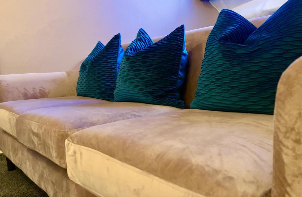 a couch with blue pillows on top of it at Westwood House in Dorchester