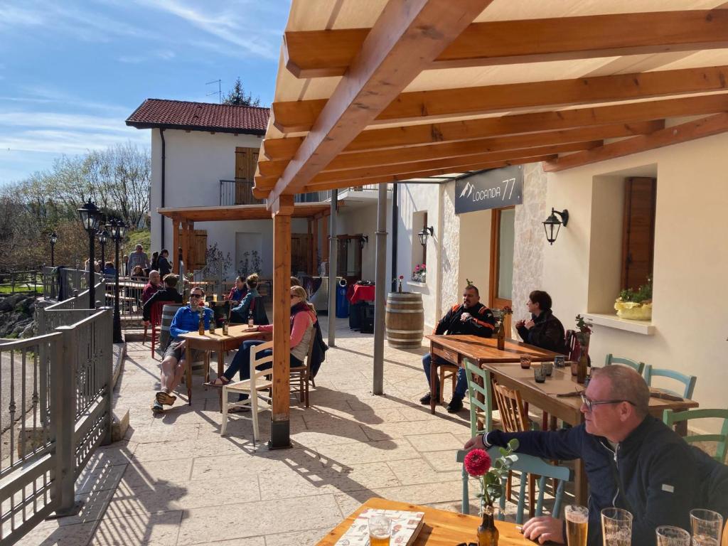 grupa ludzi siedzących przy stolikach w restauracji w obiekcie Locanda 77 w mieście Borso del Grappa
