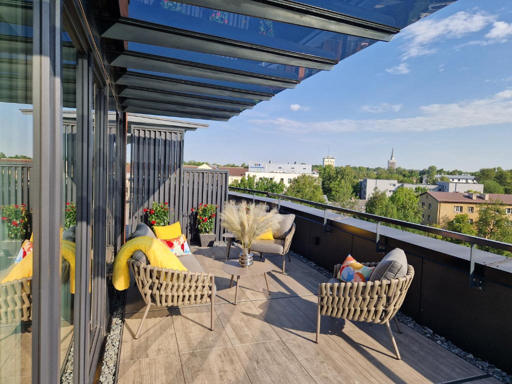 uma varanda com cadeiras e mesas num telhado em Artisa Riia Str 20a Luxury 2BR Penthouse Apartment em Tartu
