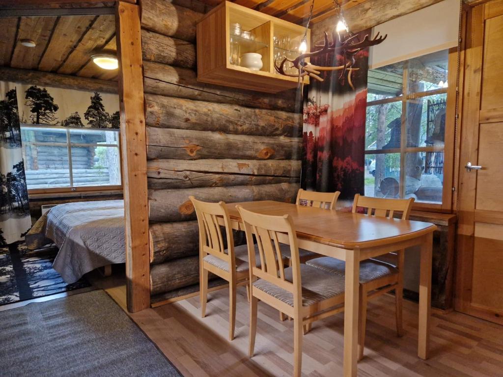 a dining room with a table and chairs and a bed at Korpikelo in Ylläsjärvi