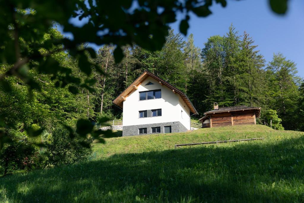 een wit huis bovenop een grasheuvel bij Holiday House Chilly in Kotlje