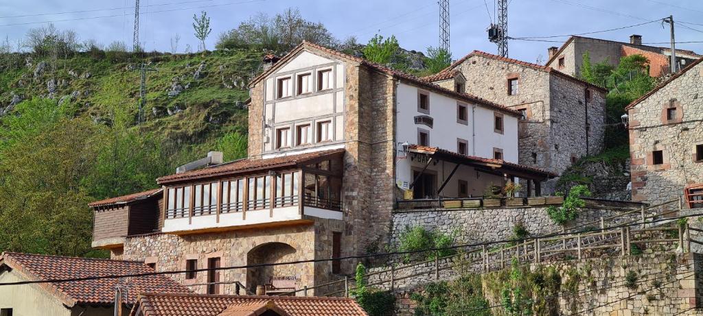 un grupo de edificios al lado de una montaña en Taberna de Tresviso en Tresviso