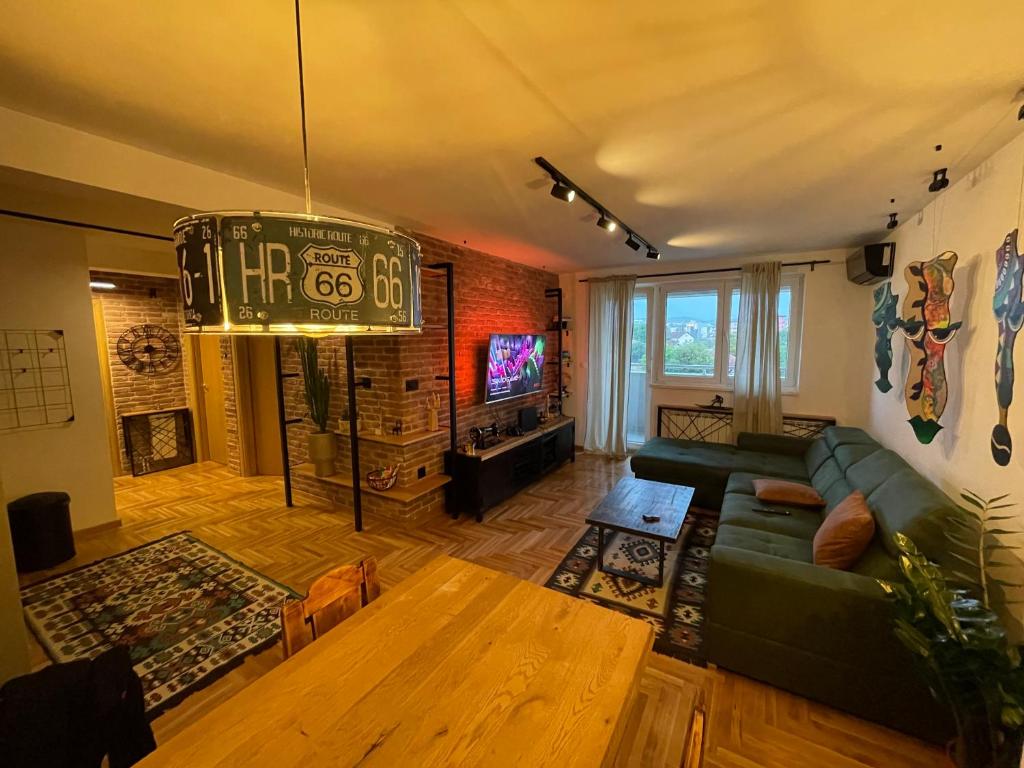 塞拉耶佛的住宿－SanPedro - Industrial Elegance，客厅配有绿色沙发和电视