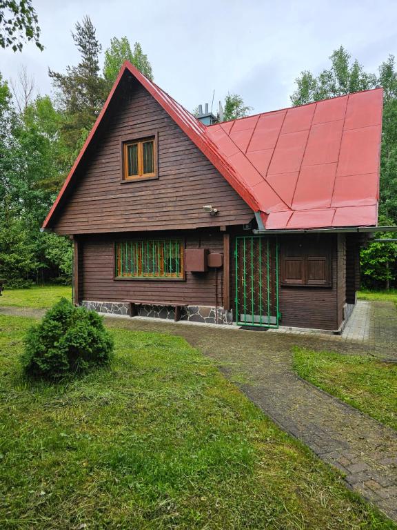 une maison avec un toit rouge et une cour dans l'établissement Chata Dajana, à Stará Lesná