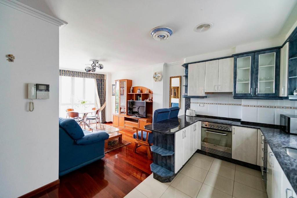 kuchnia z białymi szafkami i niebieską kanapą w obiekcie APARTAMENTO AVELINA w mieście Monforte de Lemos
