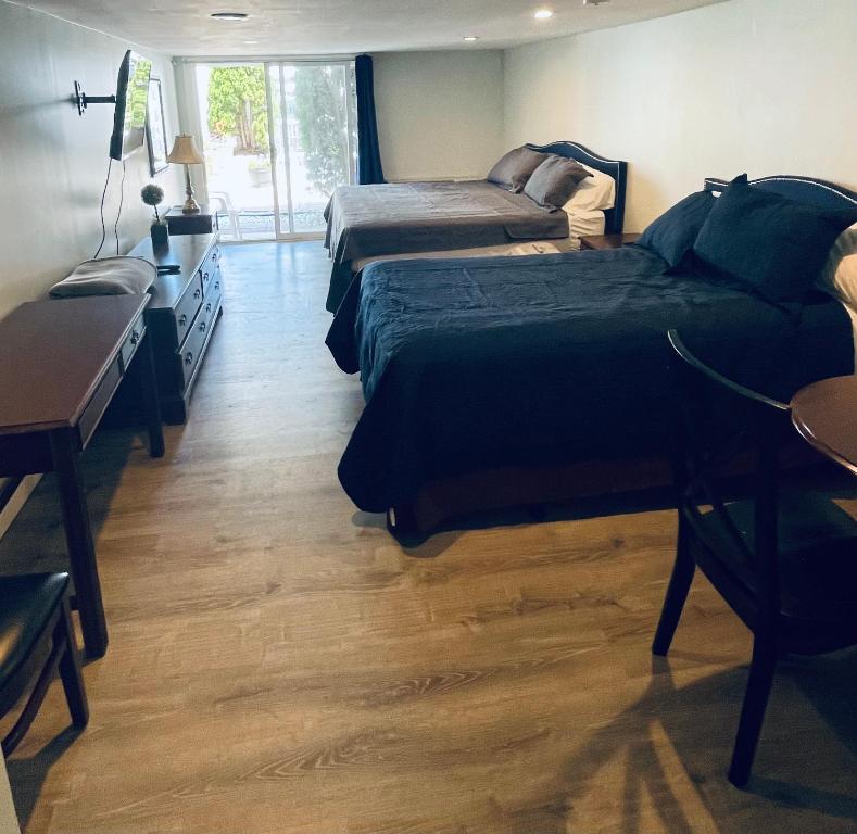 sypialnia z 2 łóżkami, biurkiem i biurkiem w obiekcie Ships Inn w mieście Hampton
