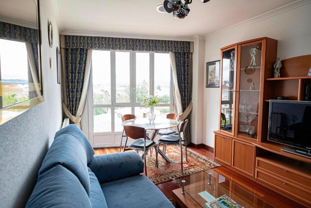 salon z niebieską kanapą i stołem w obiekcie APARTAMENTO AVELINA w mieście Monforte de Lemos