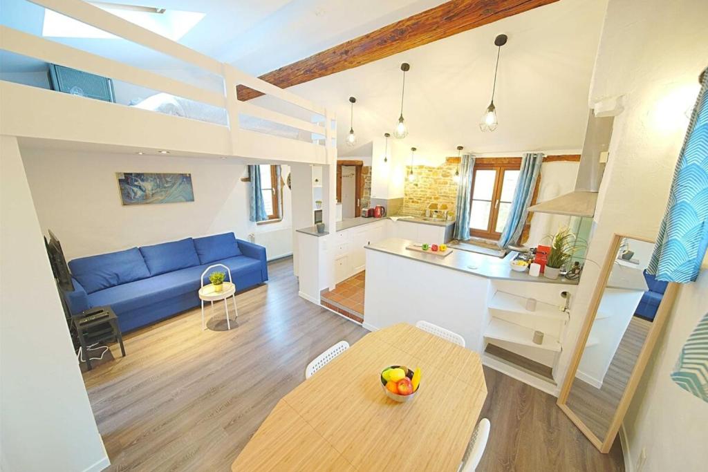 - un salon et une cuisine avec un canapé bleu et une table dans l'établissement The Fernand-Panoramic View-Sathonay-Terreaux, à Lyon