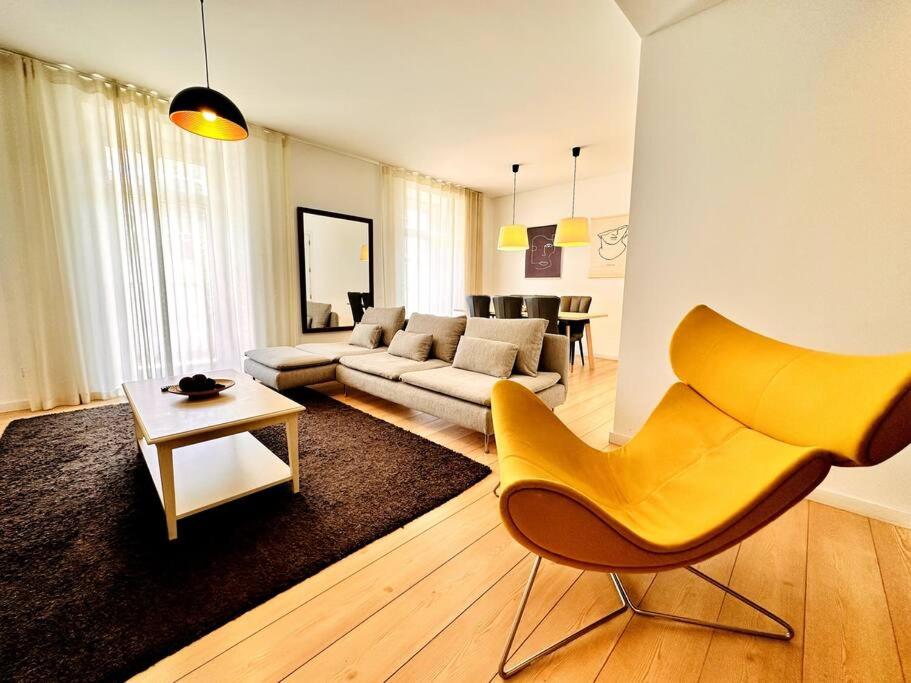 a living room with a yellow chair and a couch at Lucky Alameda Apartment in Lisbon