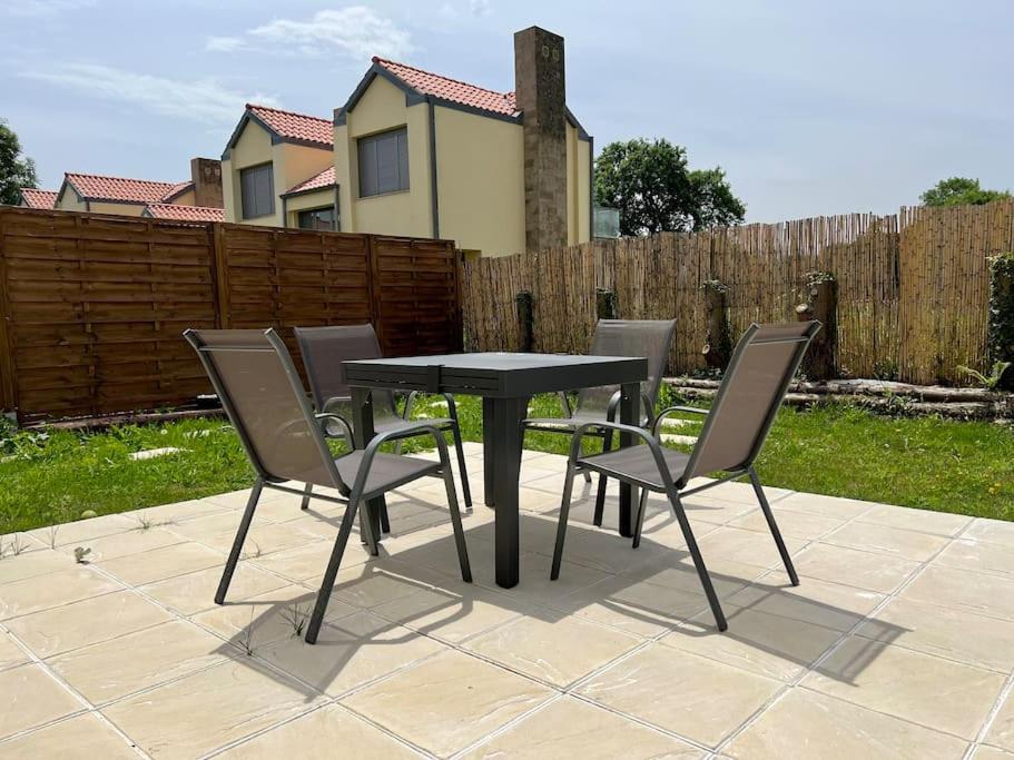 - une table et des chaises noires sur la terrasse dans l'établissement Chalet en Hazas de Cesto, à Hazas de Cesto