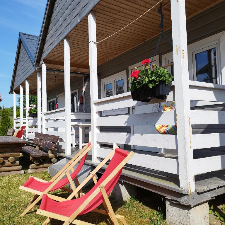 twee stoelen op de veranda van een huis bij Domki Letniskowe Meduza in Jarosławiec