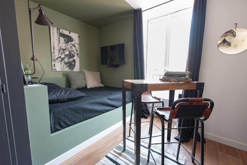 une chambre avec un lit, un bureau et une table dans l'établissement Studio L'Atelier - Metro Valmy - Vaise, à Lyon