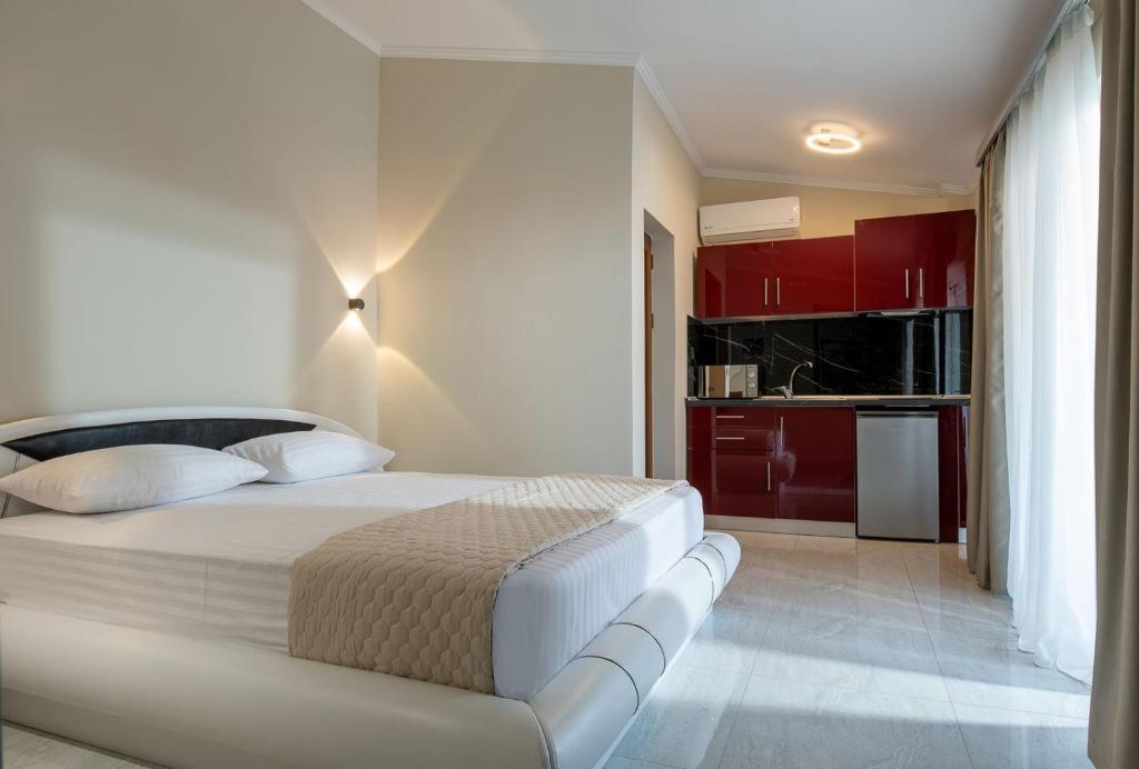 a bedroom with a white bed and red cabinets at Velky Sen Luxury Apartments in Sarti