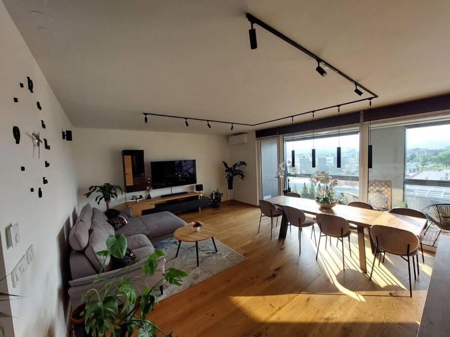 ein Wohnzimmer mit einem Sofa und einem Tisch mit Stühlen in der Unterkunft Luxury Apartment Ljubljana in Ljubljana