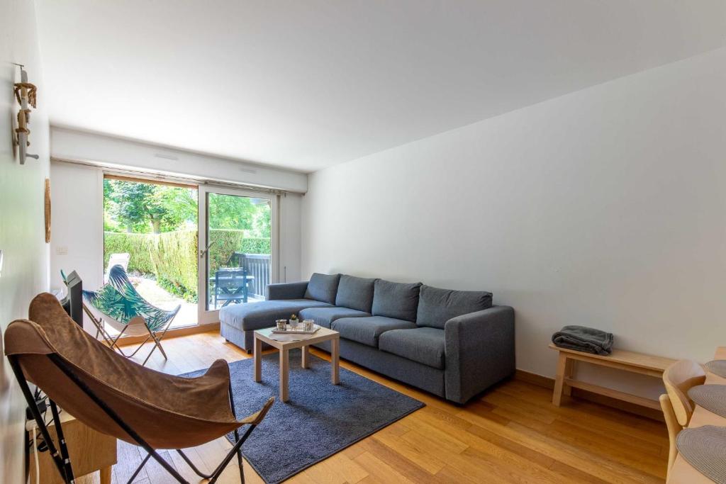 uma sala de estar com um sofá e uma mesa em Magnificent 8P2BR apartment with indoor pool and garden - Deauville em Deauville