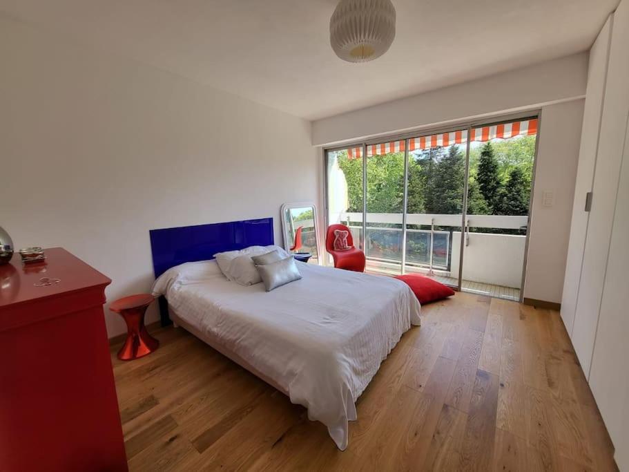 a bedroom with a bed and a large window at Superbe T3 lumineux sur parc arboré avec piscine in Anglet