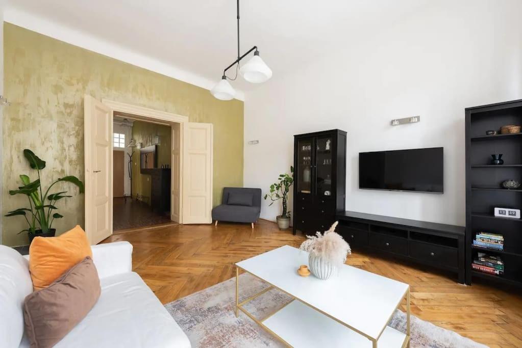 sala de estar con sofá blanco y TV en Spacious apartment with balcony at Wenceslas Sq, en Praga